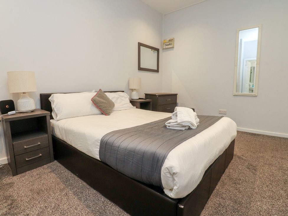 A bedroom with a bed and nightstands at Luxury Winter Gardens Apartment 1 in Blackpool