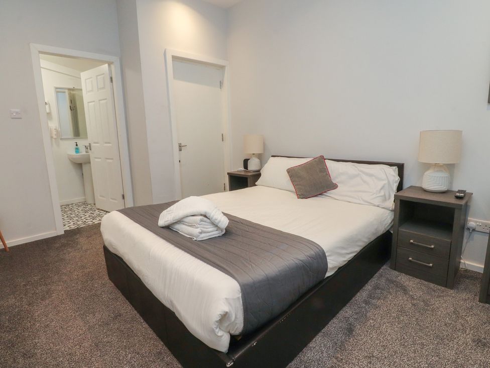 A bedroom with a bed and nightstands at Luxury Winter Gardens Apartment 1 in Blackpool