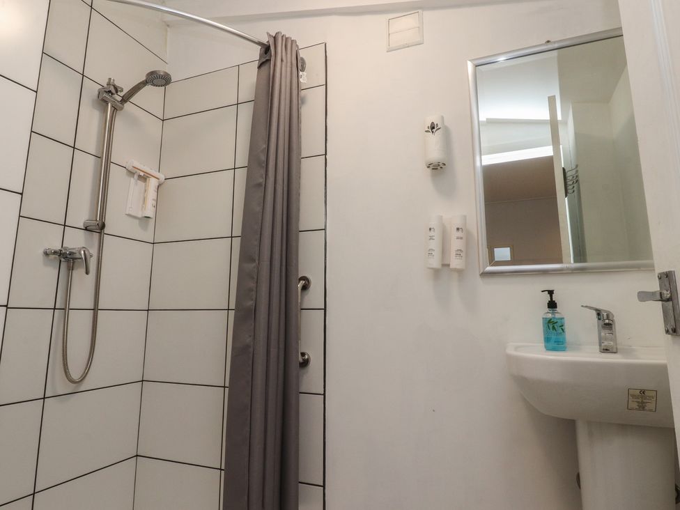 A bathroom with a shower, sink, and mirror at Luxury Winter Gardens Apartment 1 Blackpool