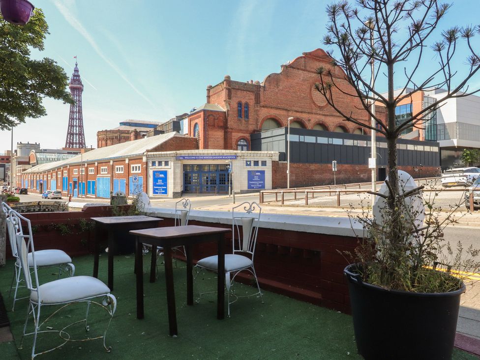 An outdoor seating area with tables and chairs at Luxury Winter Gardens Apartment 1 in Blackpool