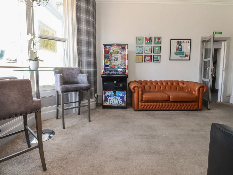 A living room with a sofa and slot machine at Luxury Winter Gardens Apartment 1 in Blackpool