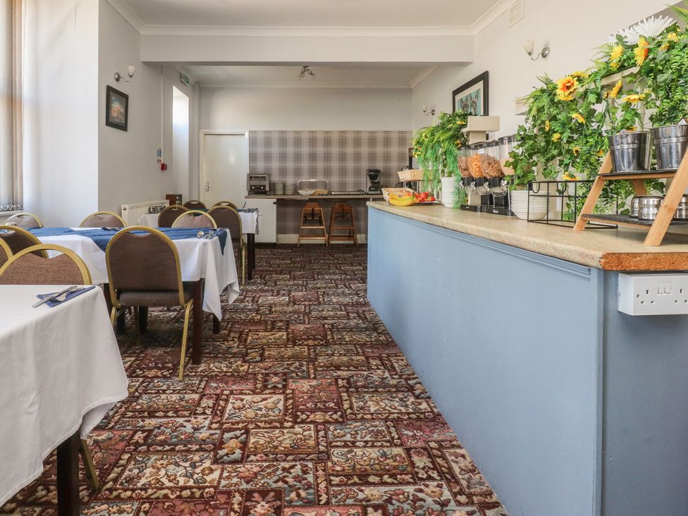 A dining room with tables and a service counter at Luxury Winter Gardens Apartment 1 in Blackpool