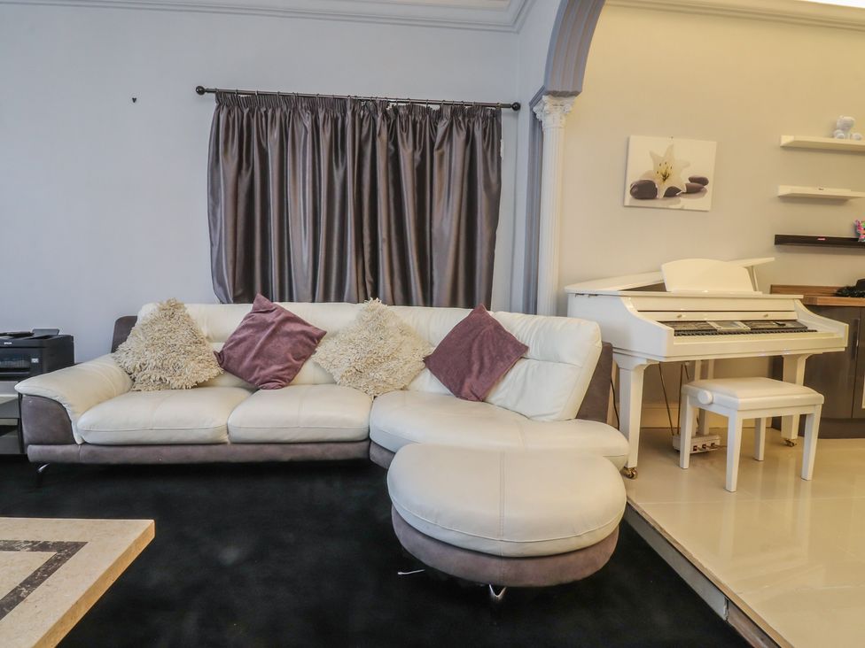 A living room with a couch and piano at Luxury Winter Gardens Apartment 2 in Blackpool