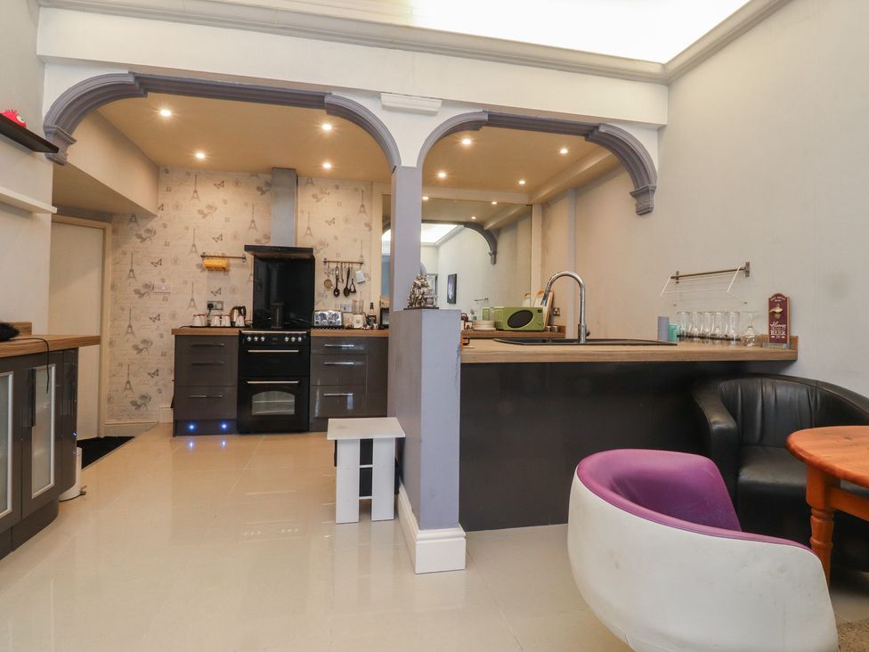A kitchen with cabinets and a dining area at Luxury Winter Gardens Apartment 2 Blackpool