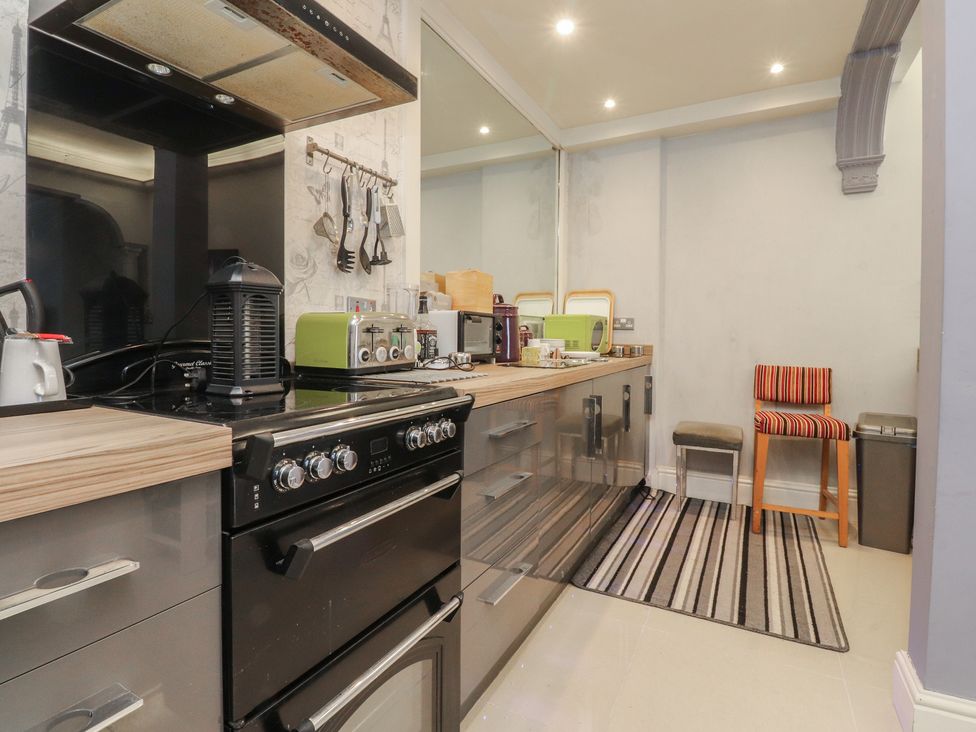A kitchen with appliances and a striped rug at Luxury Winter Gardens Apartment 2 in Blackpool