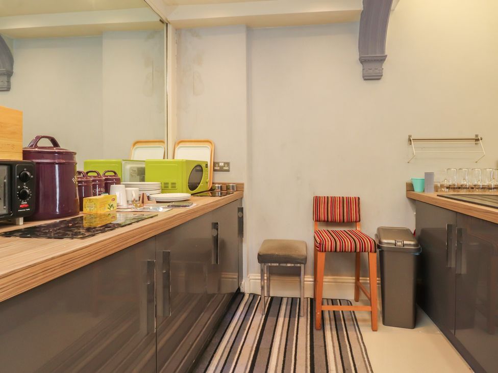 A kitchen with appliances and seating at Luxury Winter Gardens Apartment 2 in Blackpool