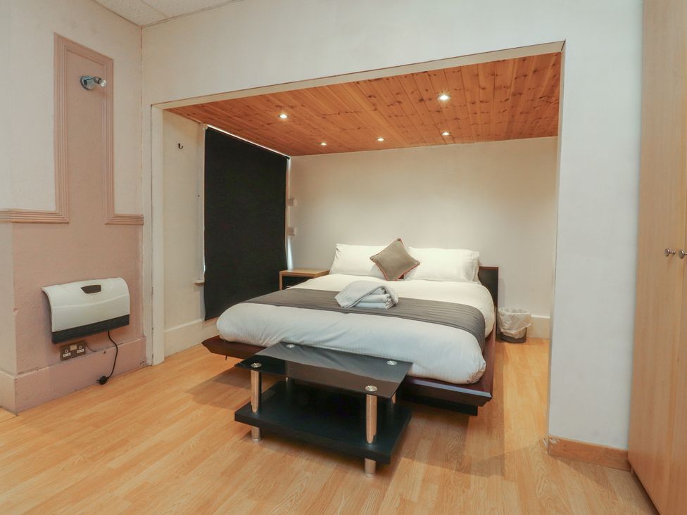A bedroom with a bed and side table at Luxury Winter Gardens Apartment 2 in Blackpool