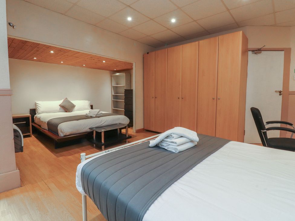 A bedroom with a bed, wardrobe, and chair at Luxury Winter Gardens Apartment 2 in Blackpool