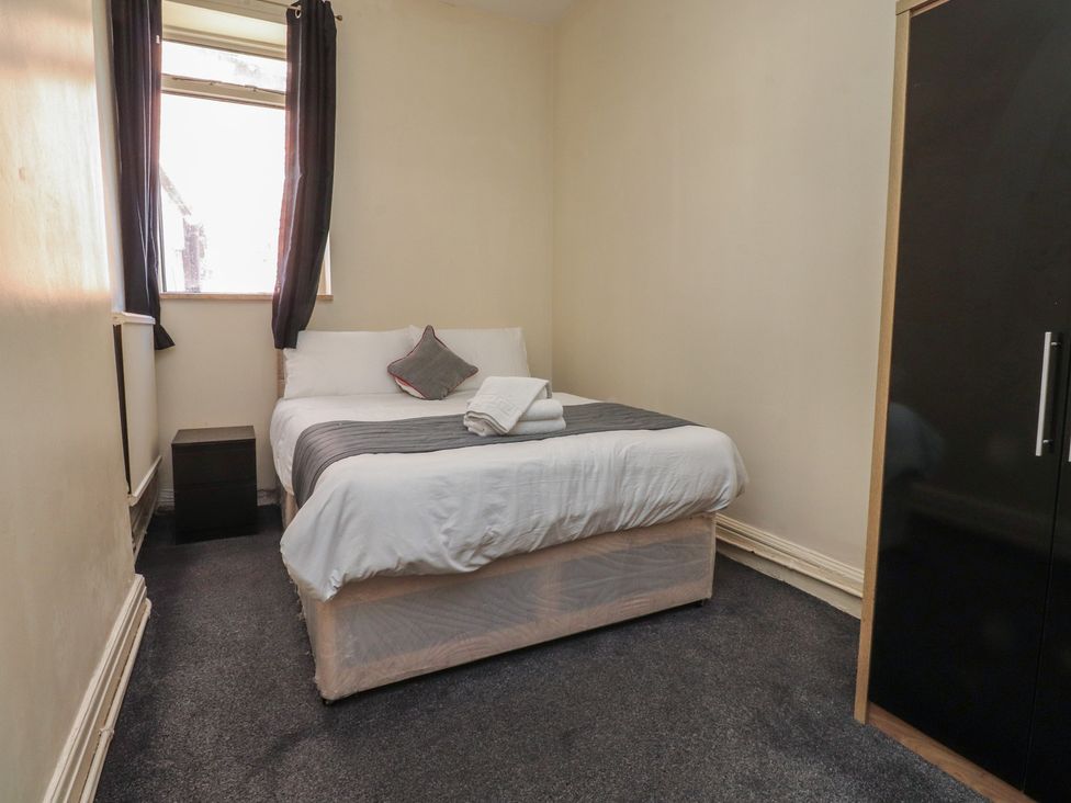 A bedroom with a bed and wardrobe at Luxury Winter Gardens Apartment 2 in Blackpool