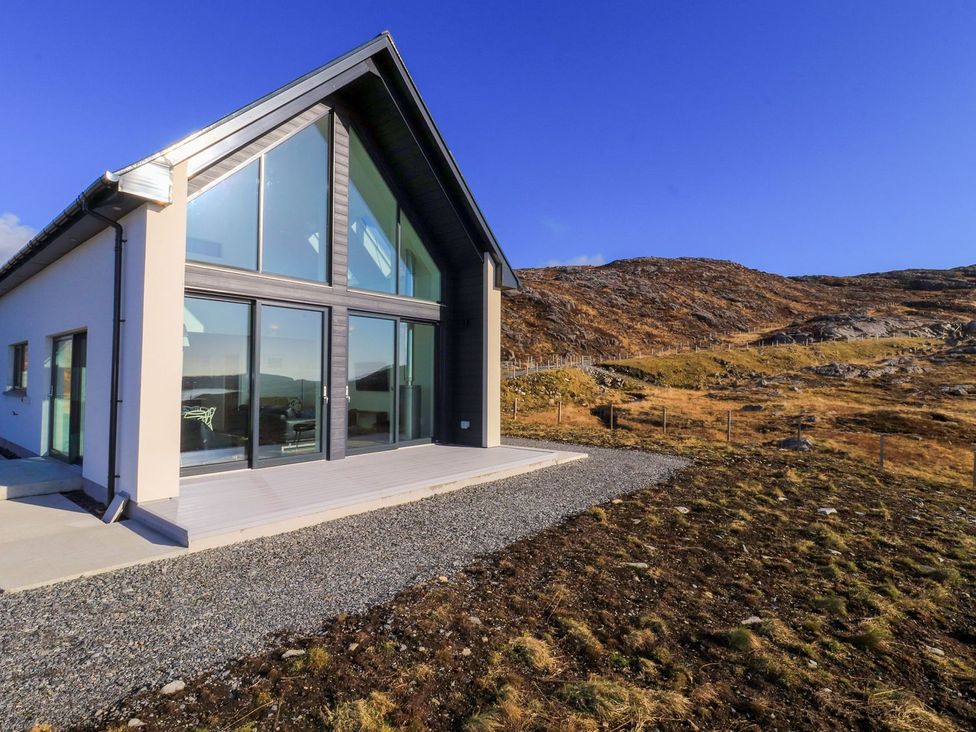 A house with large windows and a gravel path at 8B Carrigreich Isle of Harris