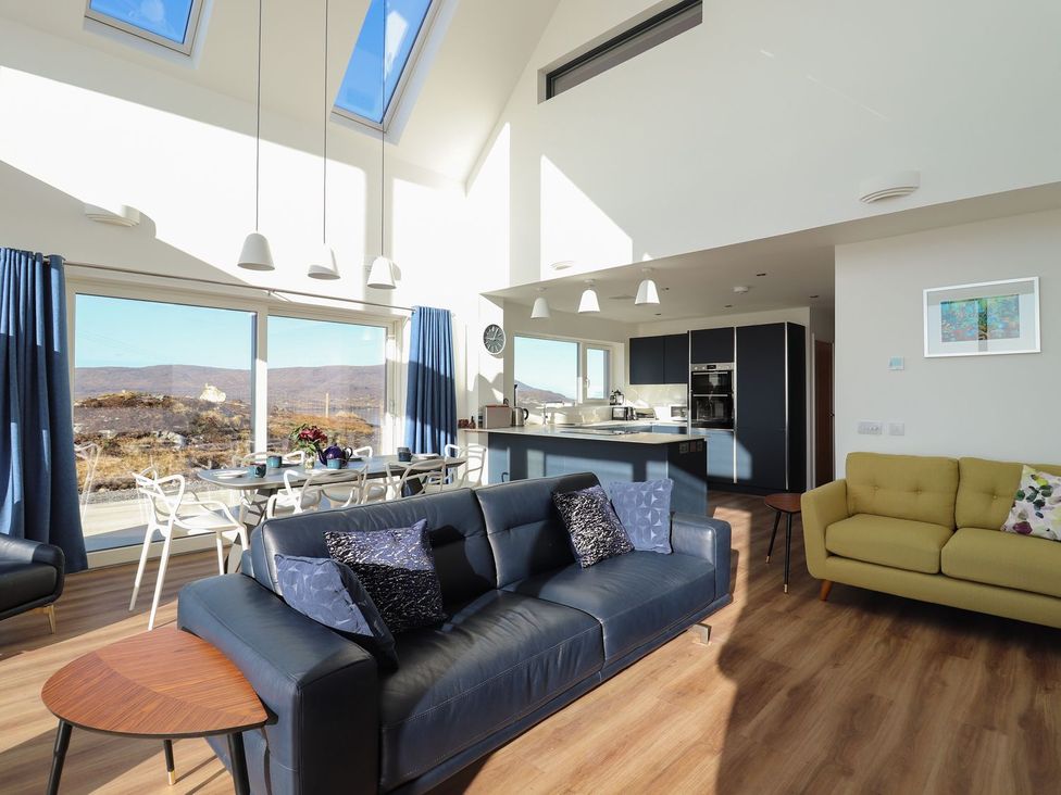 A living room with a sofa and dining area at 8B Carrigreich Isle of Harris