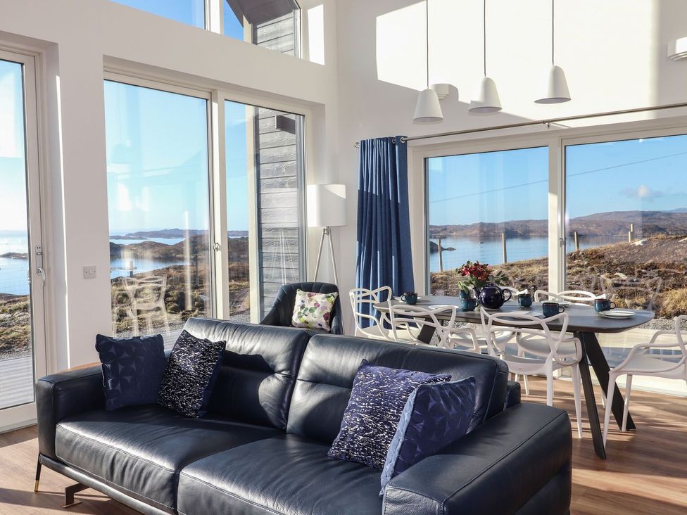 A living room with a sofa and dining area at 8B Carrigreich Isle of Harris