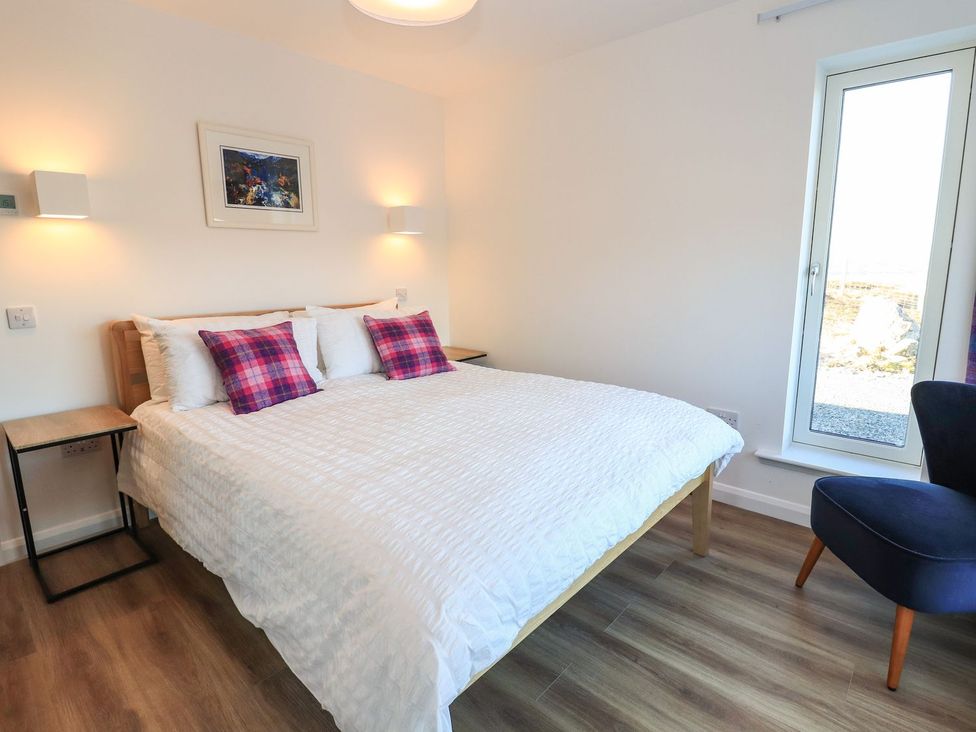 A bedroom with a bed and chair at 8B Carrigreich Isle of Harris