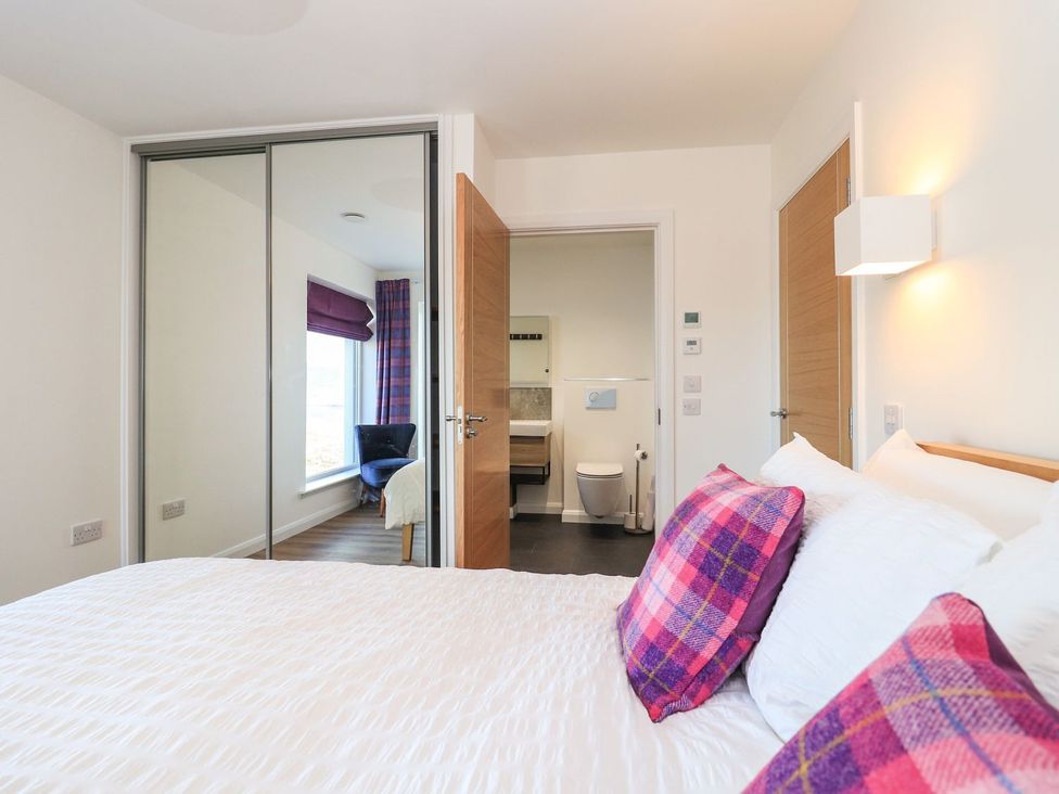 A bedroom with a bed and a bathroom visible at 8B Carrigreich Isle of Harris