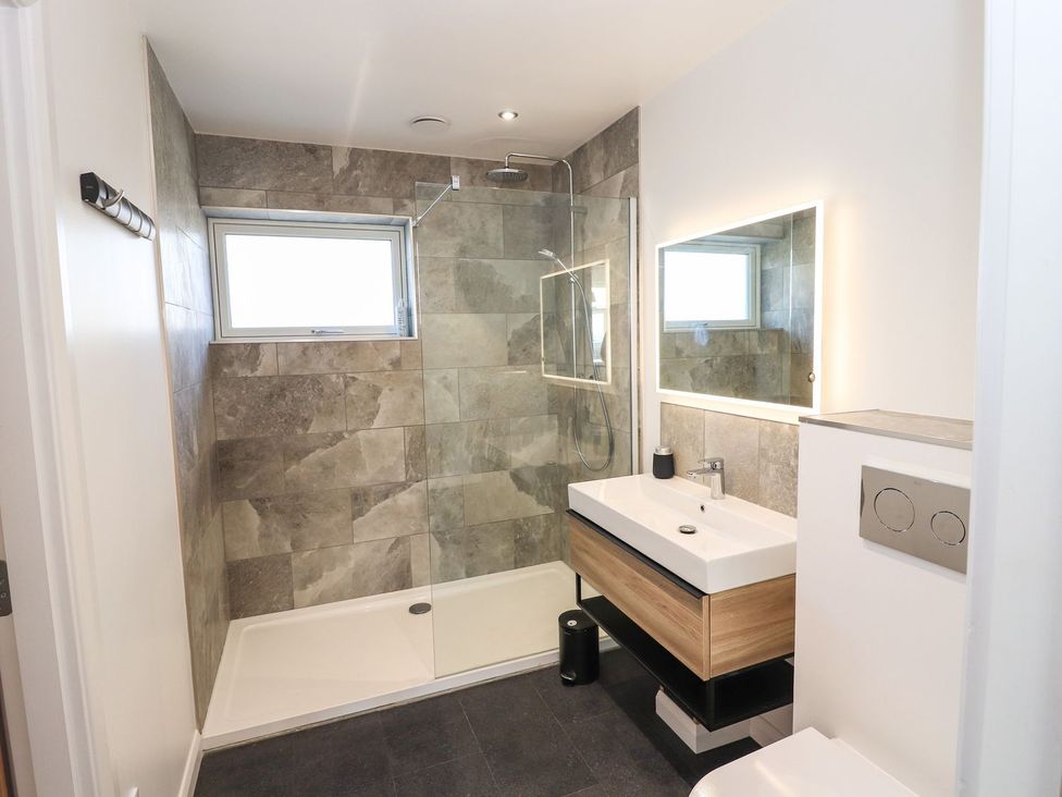 A bathroom with a shower, wash basin, and toilet at 8B Carrigreich, Isle of Harris