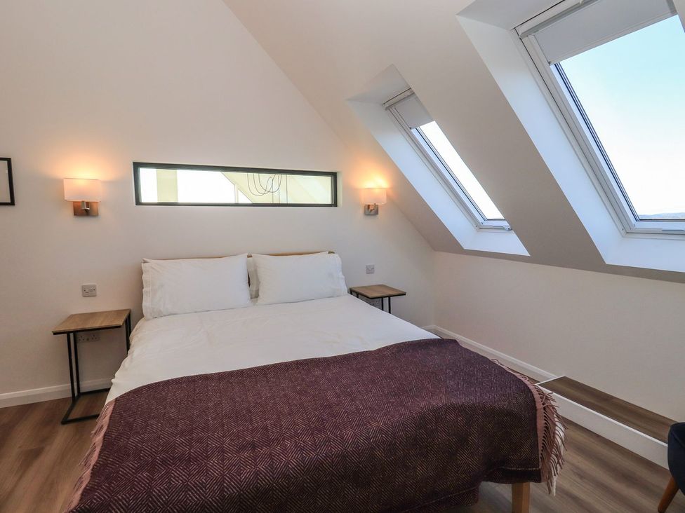 A bedroom with a bed and bedside tables at 8B Carrigreich Isle of Harris