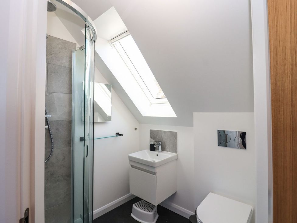 A bathroom with a shower, sink, and toilet at 8B Carrigreich Isle of Harris