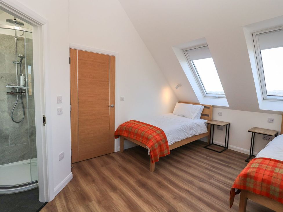 A bedroom with two beds and a shower at 8B Carrigreich in Isle of Harris