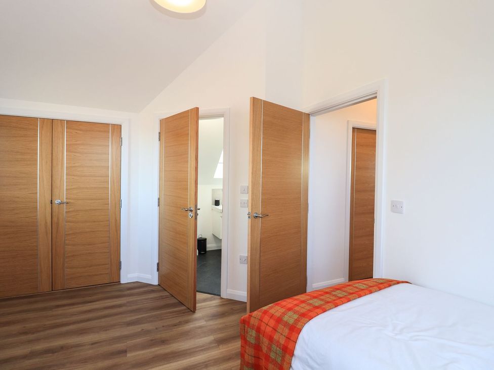 A bedroom with doors on two sides at 8B Carrigreich Isle of Harris