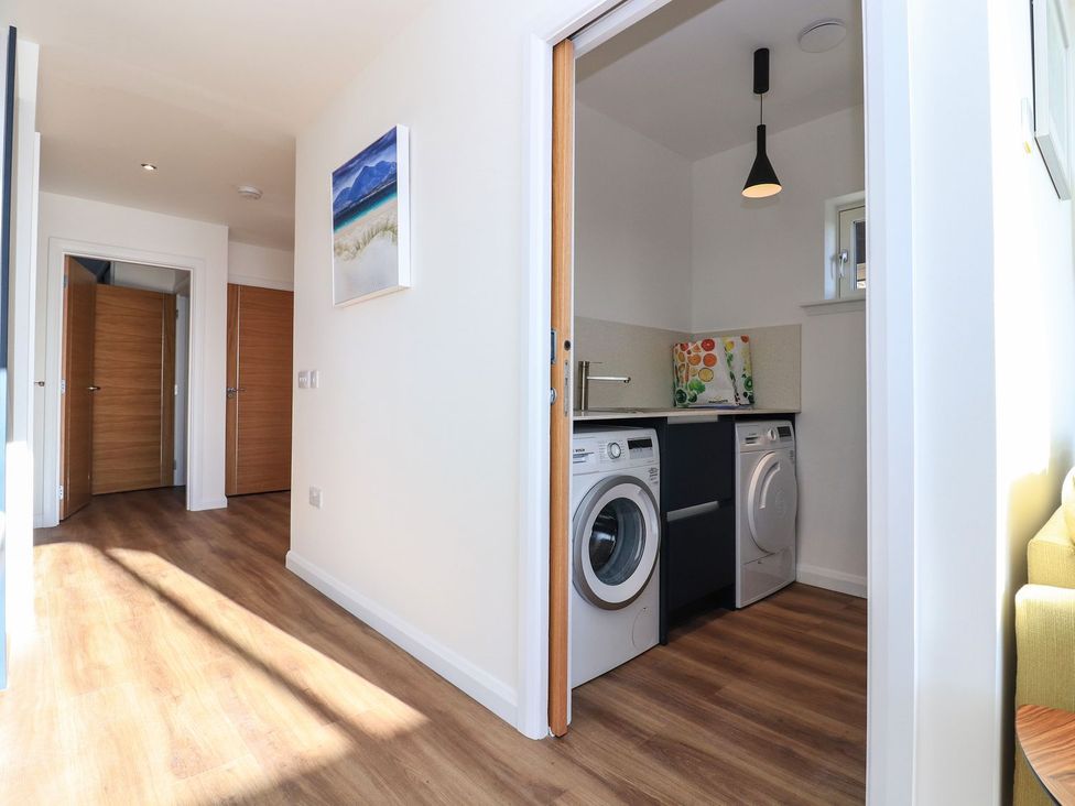A laundry room with washing machine and dryer at 8B Carrigreich in Isle of Harris