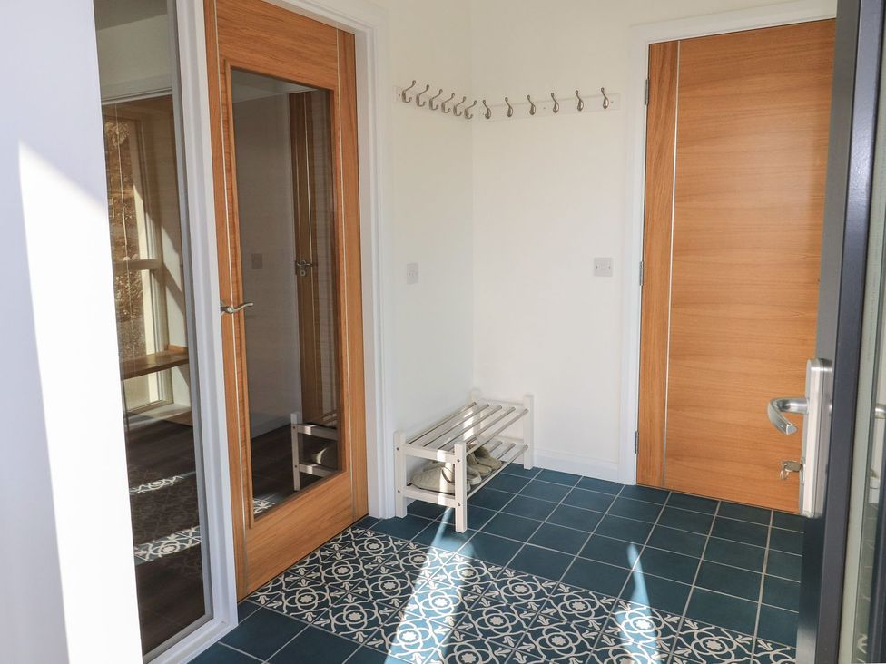 A hallway with coat hooks and a bench at 8B Carrigreich Isle of Harris