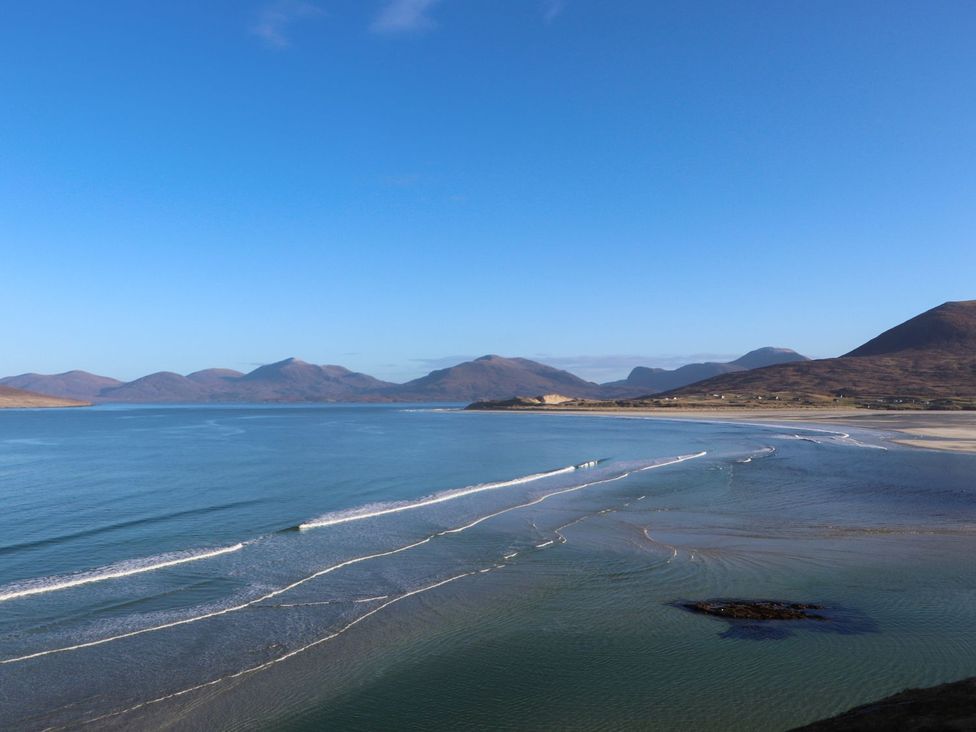 A view of waves on the sea with mountains in the background at 8B Carrigreich Isle of Harris