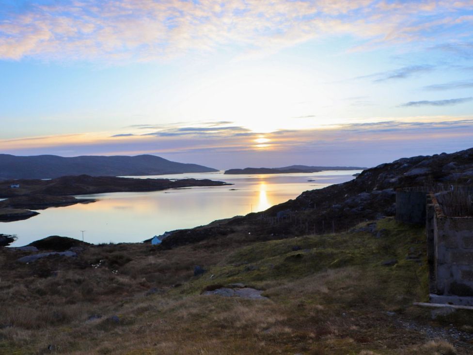 A landscape view of water and hills at sunset at 8B Carrigreich Isle of Harris