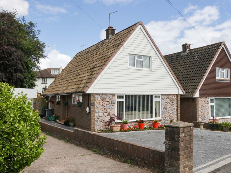 A house with a driveway and planters at Halsdon Avenue in Exmouth