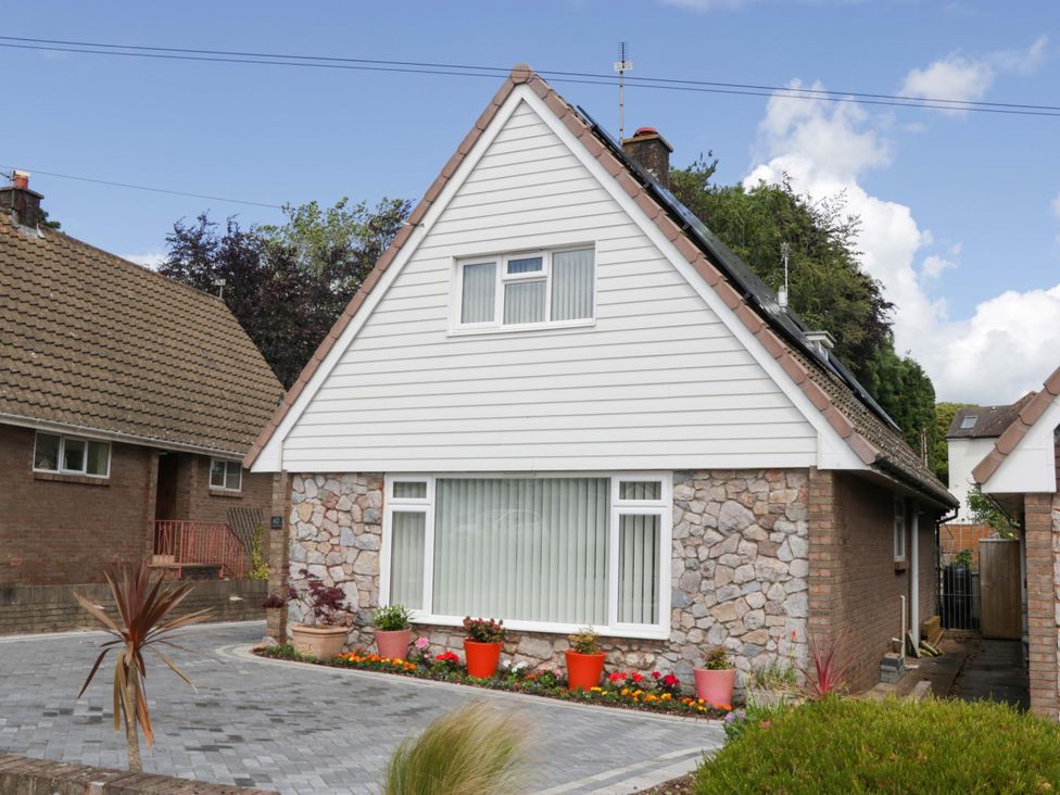 A house with a stone exterior and garden at Halsdon Avenue Exmouth