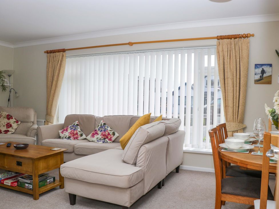 A living room with sofa and dining area at Halsdon Avenue in Exmouth