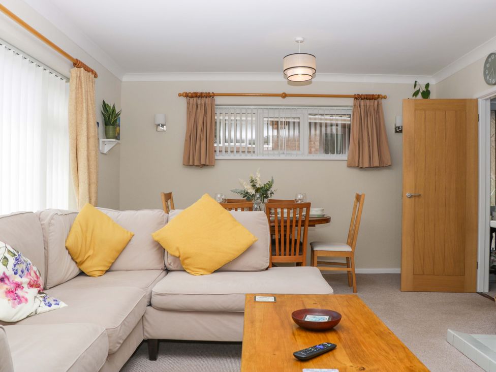 A living room with a sofa and dining area at Halsdon Avenue in Exmouth