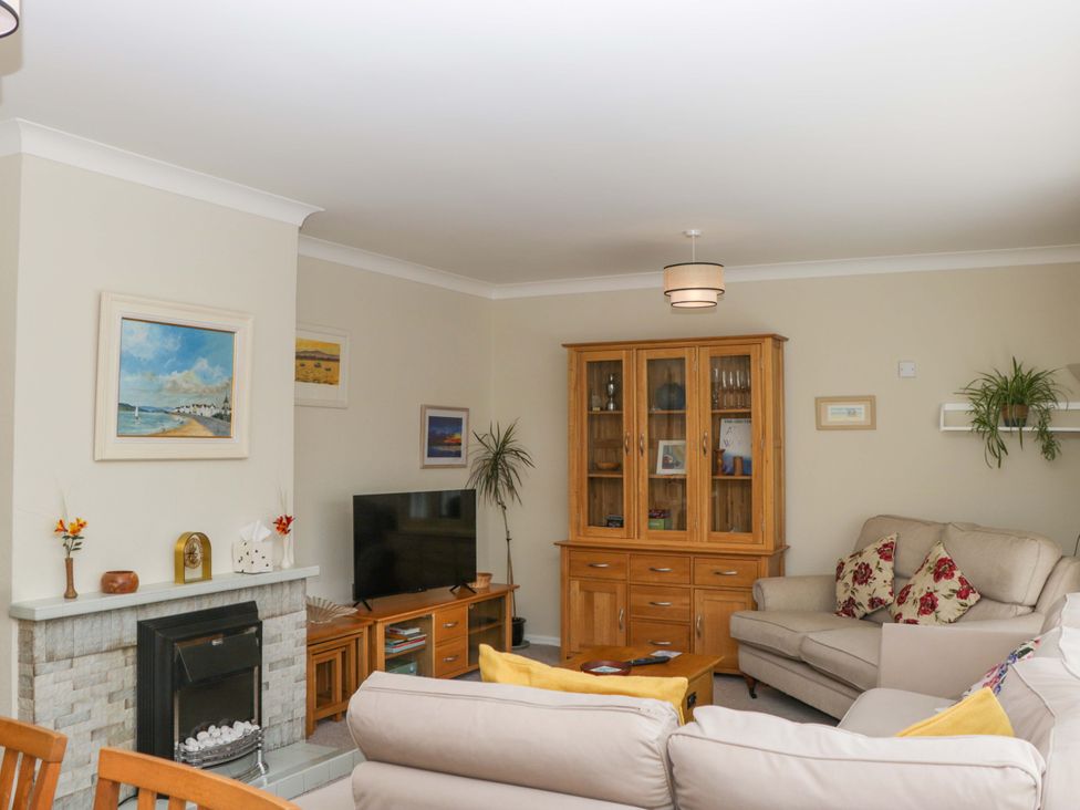 A living room with a sofa and television at Halsdon Avenue in Exmouth