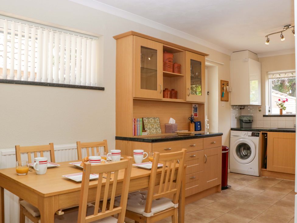 A kitchen with a dining table and chairs at Halsdon Avenue in Exmouth