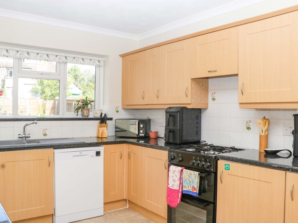 A kitchen with a sink, dishwasher, and oven at Halsdon Avenue in Exmouth