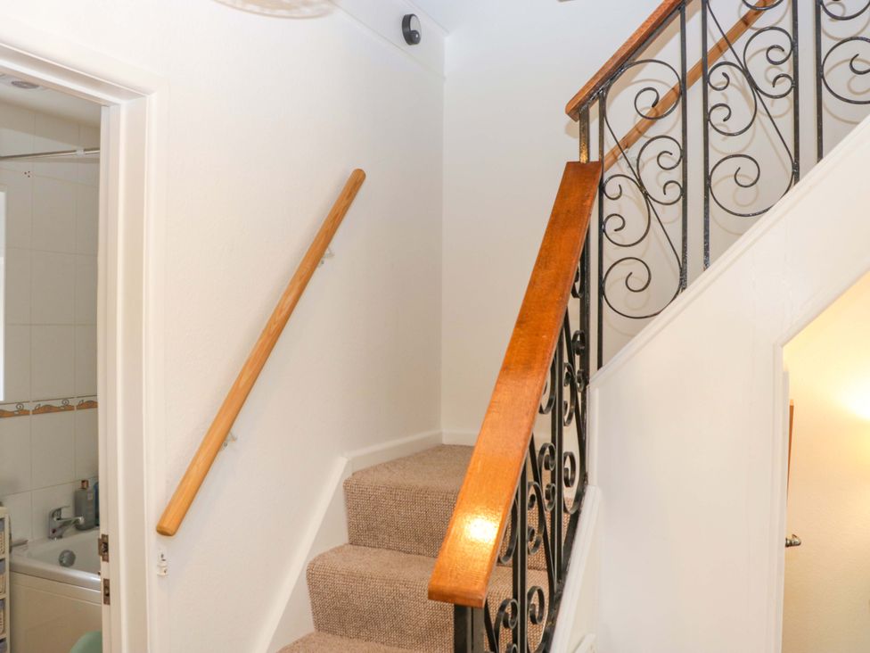 A staircase with a wooden handrail and a door to the bathroom at Halsdon Avenue in Exmouth