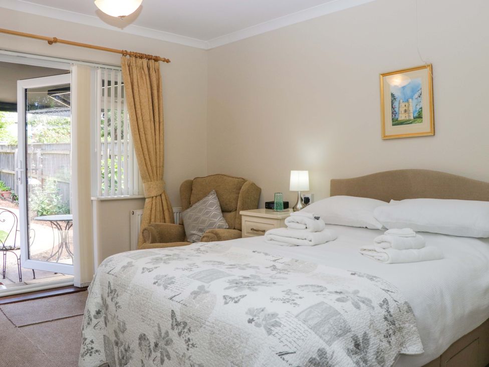 A bedroom with a bed and an armchair at Halsdon Avenue in Exmouth
