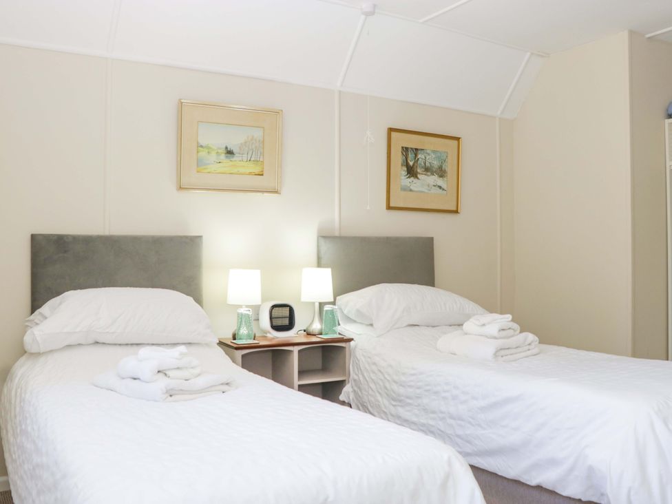 A bedroom with two beds and a nightstand at Halsdon Avenue in Exmouth