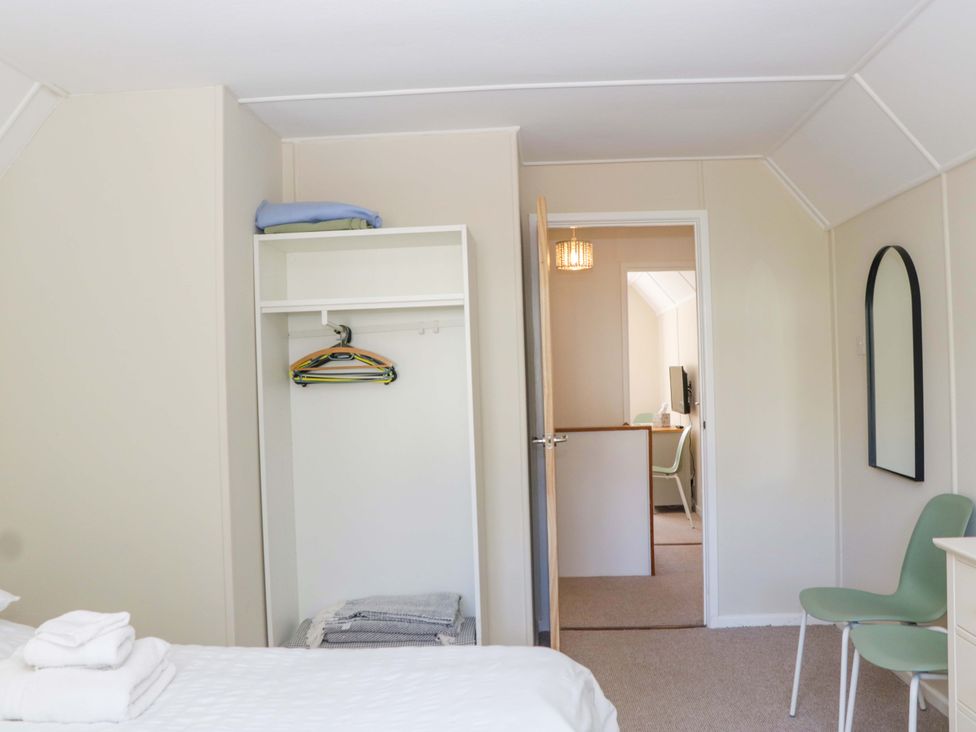 A bedroom with a bed and shelves in view at Halsdon Avenue Exmouth
