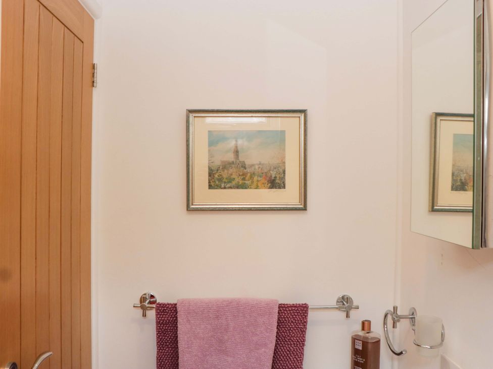 A bathroom with a framed picture and towel rack at Halsdon Avenue in Exmouth