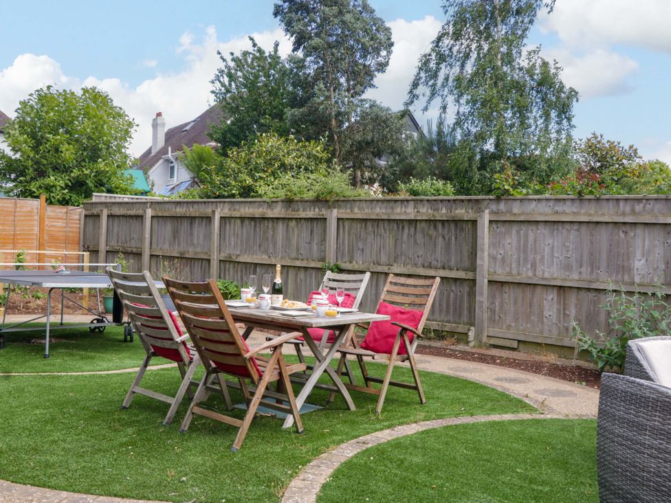 A garden with a table and chairs and a ping pong table at Halsdon Avenue, Exmouth