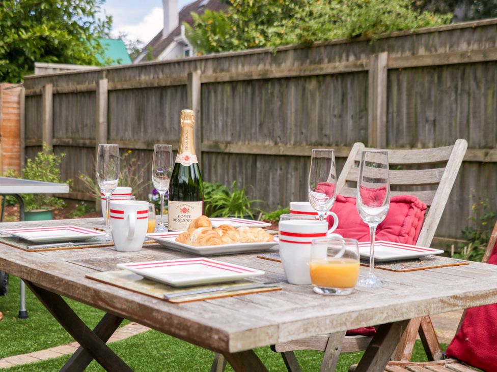 A garden table set for breakfast with drinks and pastries at Halsdon Avenue in Exmouth