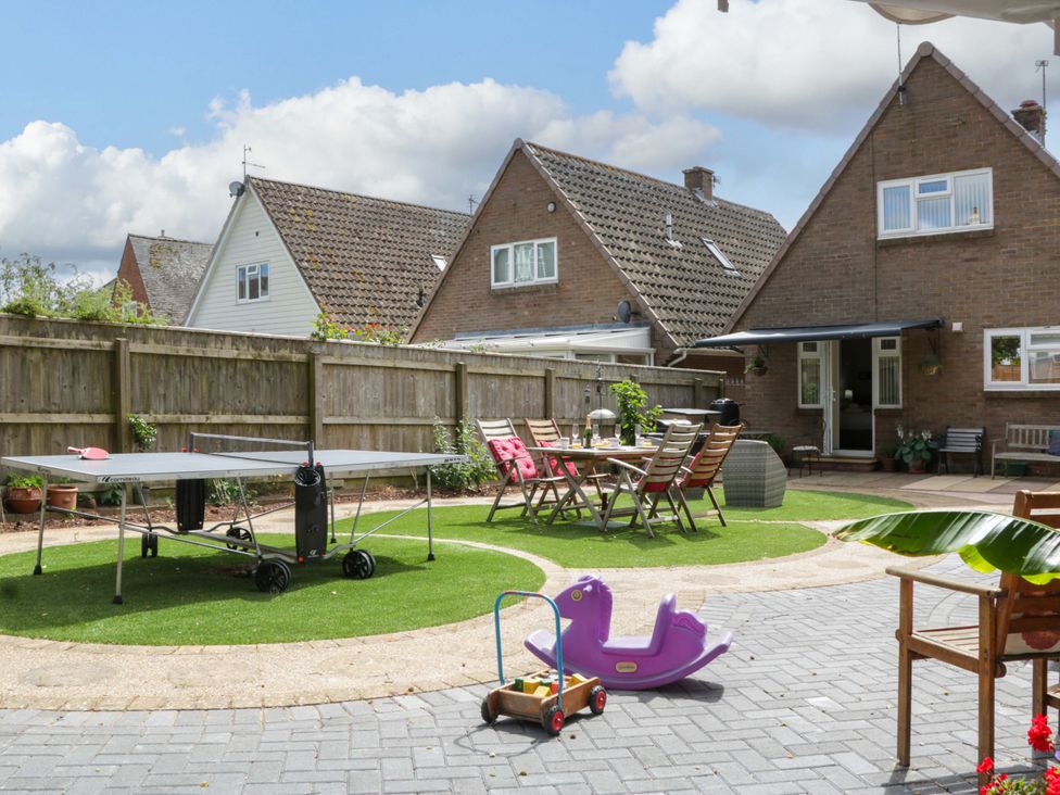 A garden with a ping pong table and seating area at Halsdon Avenue, Exmouth