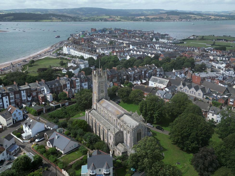 An aerial view of a church surrounded by houses near the sea at Halsdon Avenue in Exmouth