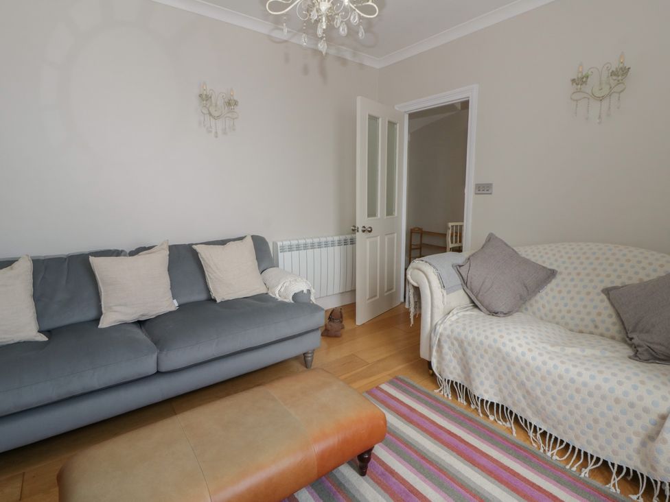 A living room with a sofa and a rug at Arosfa New Quay