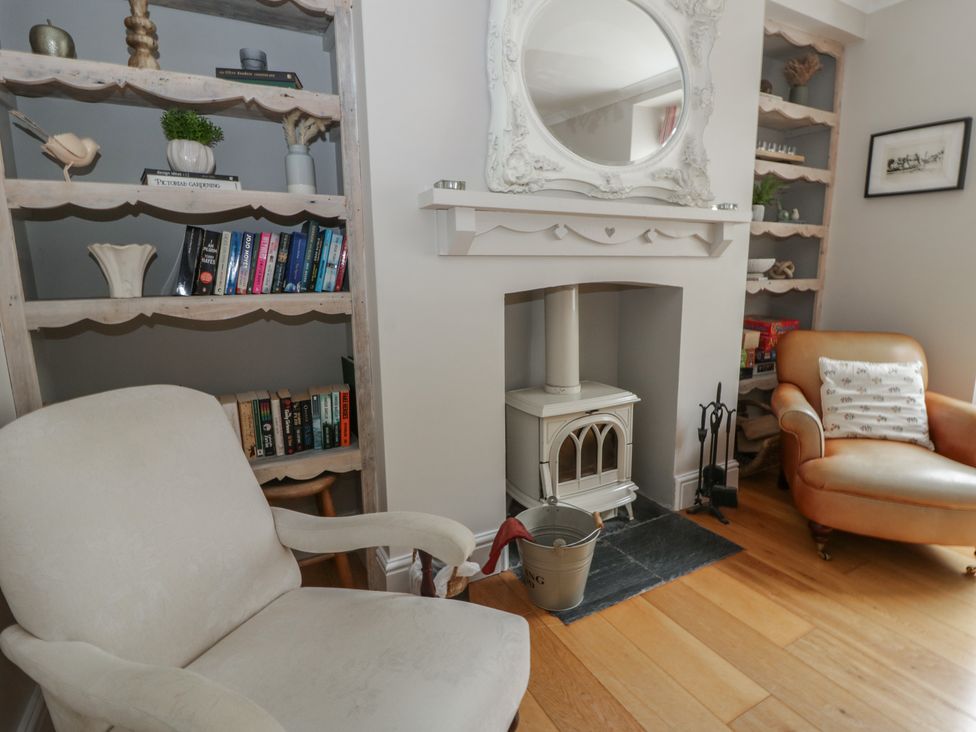 A living room with a bookshelf and a fireplace at Arosfa New Quay