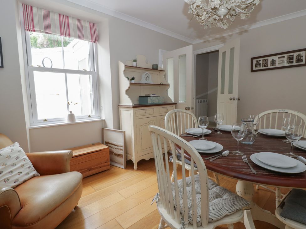 A dining room with a table set for a meal at Arosfa New Quay