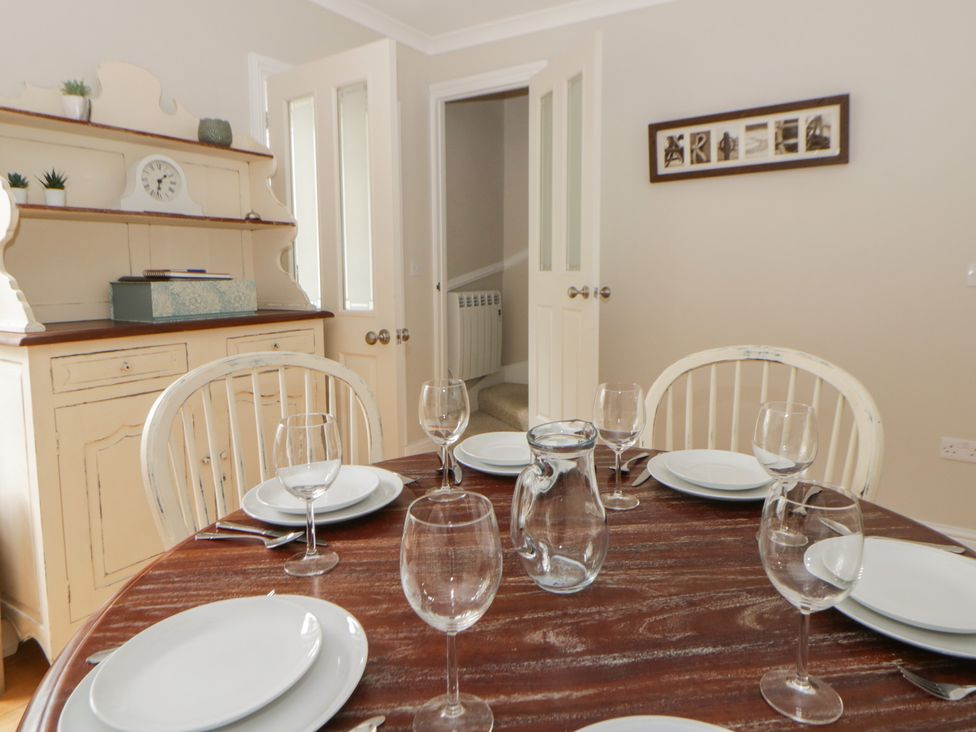 A dining room with a table set for six at Arosfa in New Quay