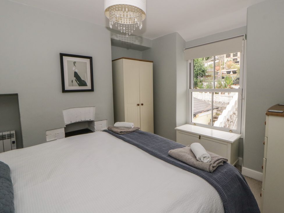 A bedroom with a bed and wardrobe at Arosfa New Quay