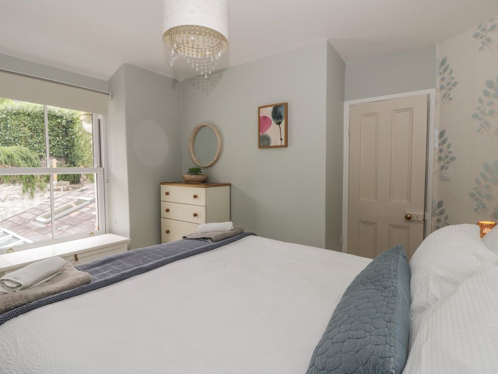 A bedroom with a bed and a window at Arosfa New Quay