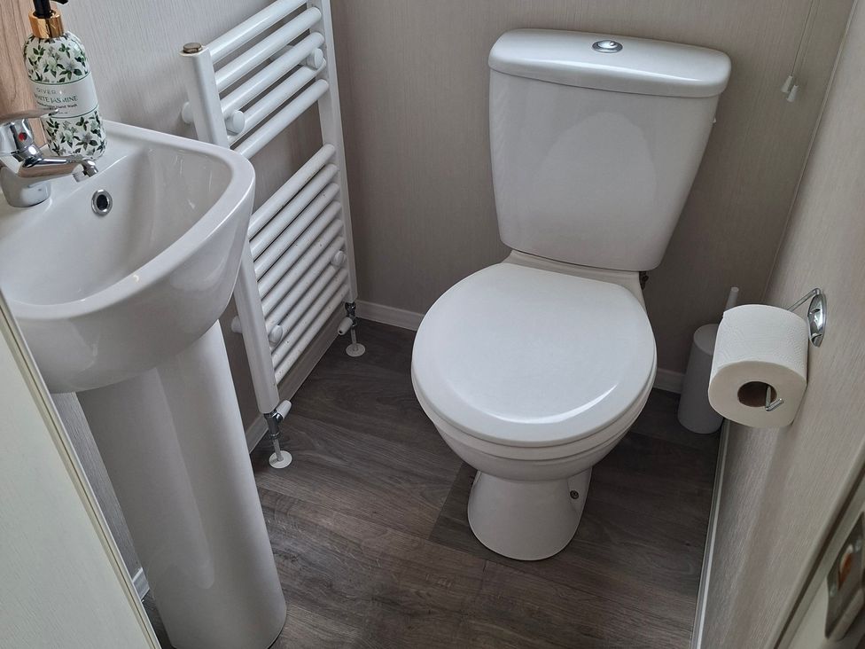 A bathroom with a sink and toilet at Primrose Valley, Amara's Retreat in Filey